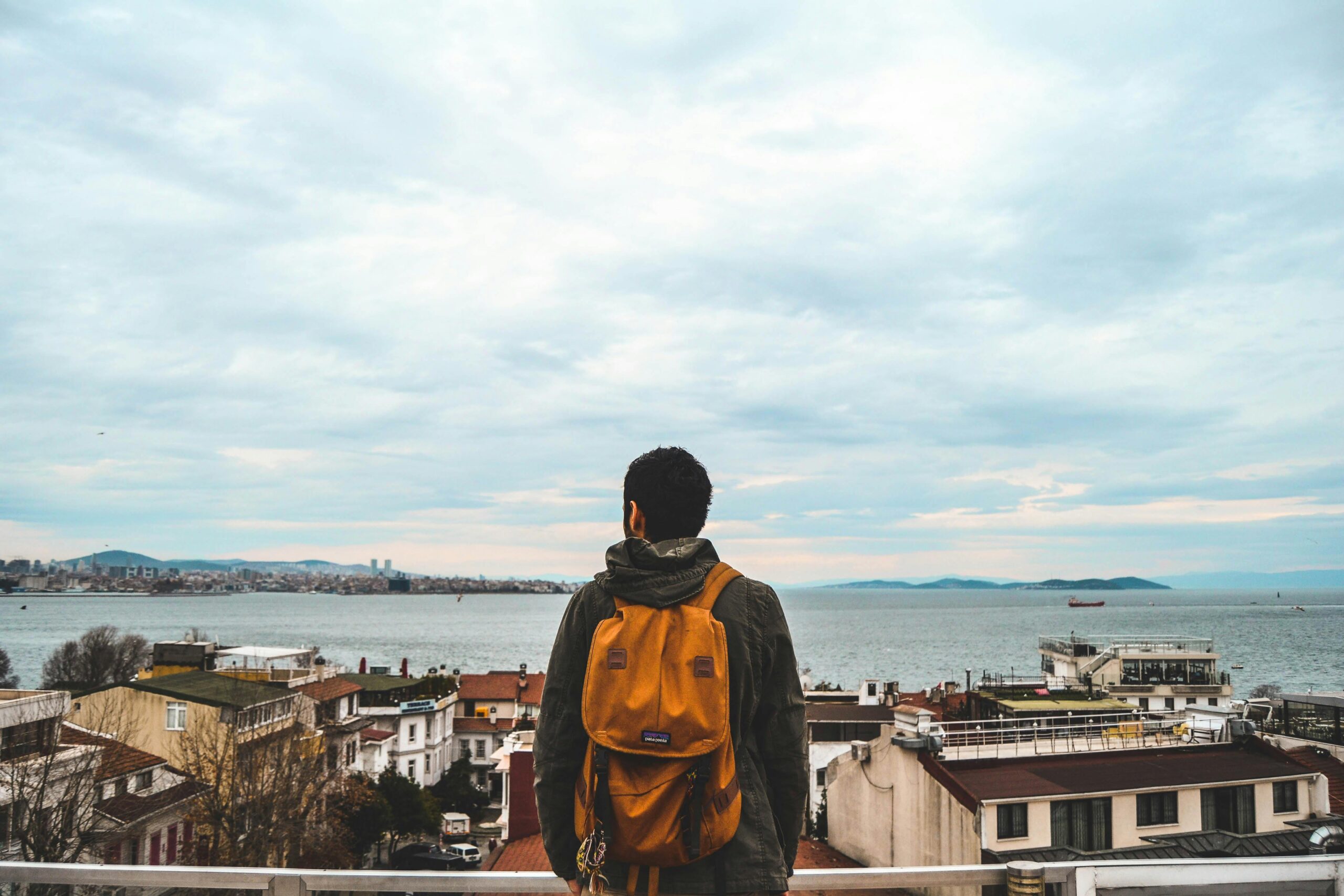 Man with a backpack overlooks the stunning seaside skyline of Istanbul, Turkey.